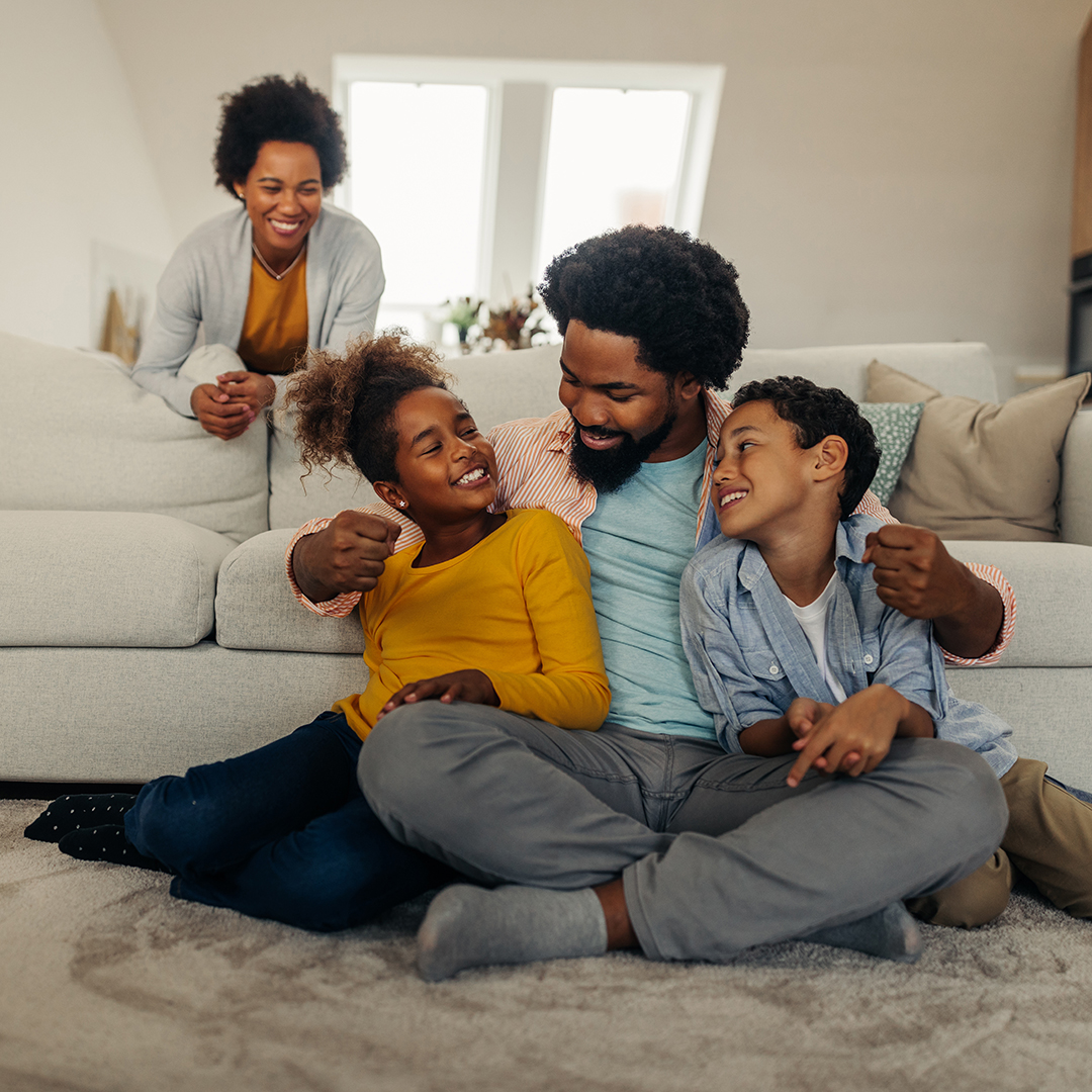 Afro parents and children having fun and smiling while spending weekend at home