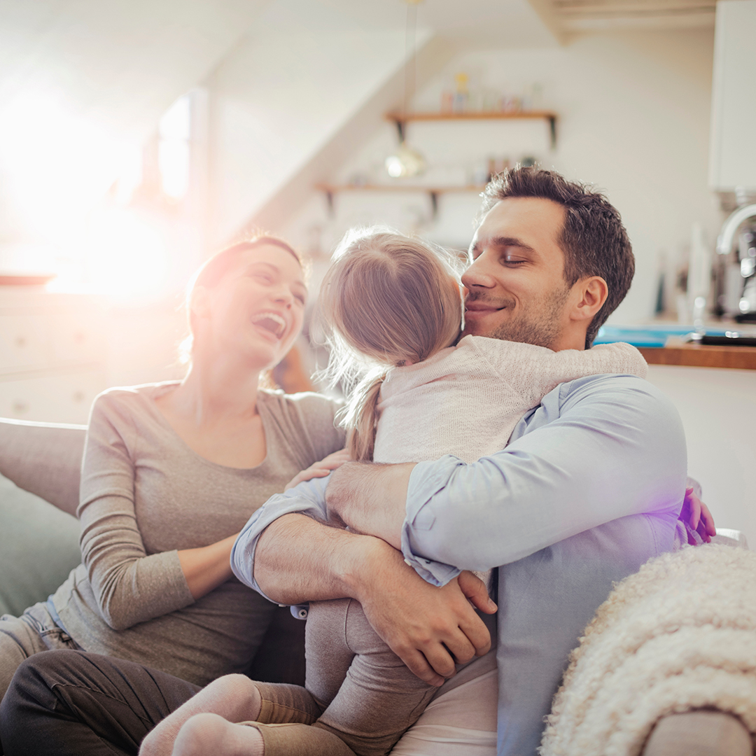 Happy young family relaxing on the couch at home
